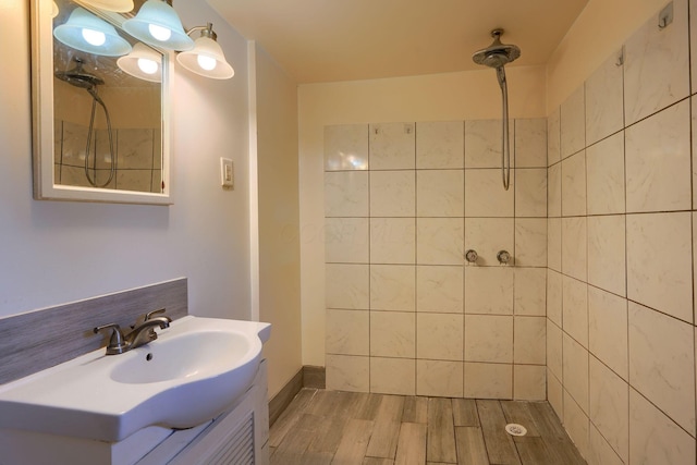 bathroom featuring vanity, hardwood / wood-style floors, and a tile shower