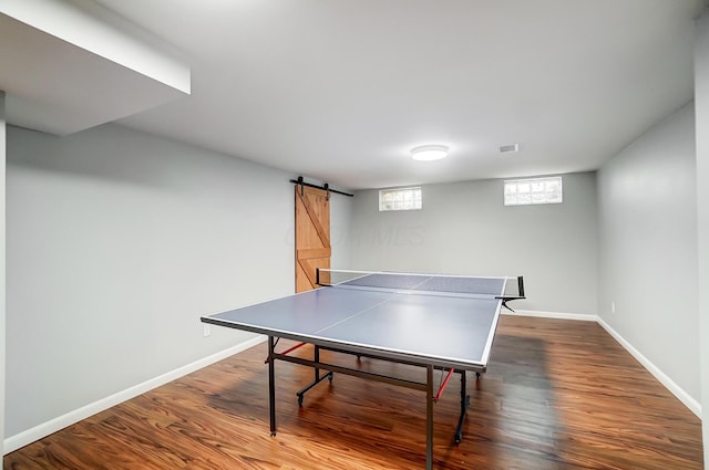 recreation room with dark hardwood / wood-style floors and a barn door