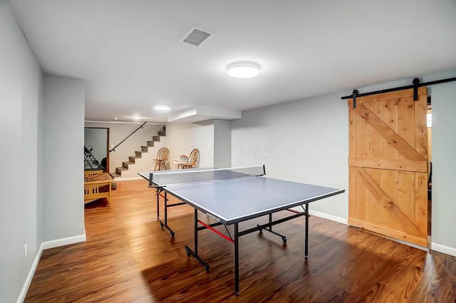 game room with wood-type flooring and a barn door