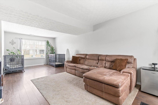 living room with wood finished floors, baseboards, and a textured ceiling