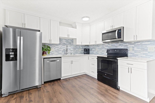 kitchen featuring a sink, light countertops, white cabinets, dark wood-type flooring, and appliances with stainless steel finishes