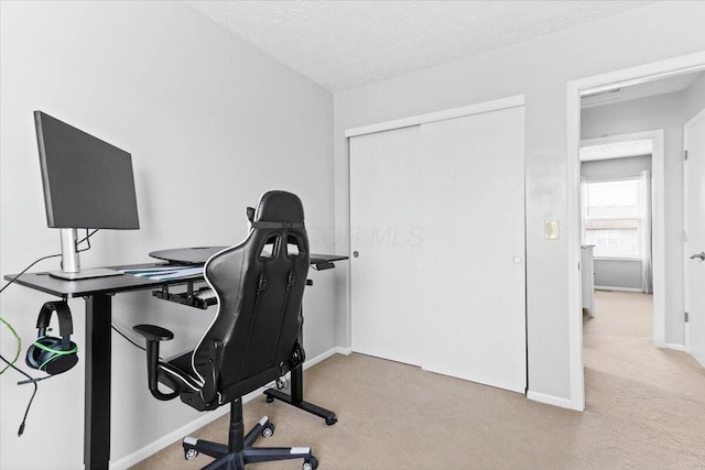 home office featuring carpet, baseboards, and a textured ceiling