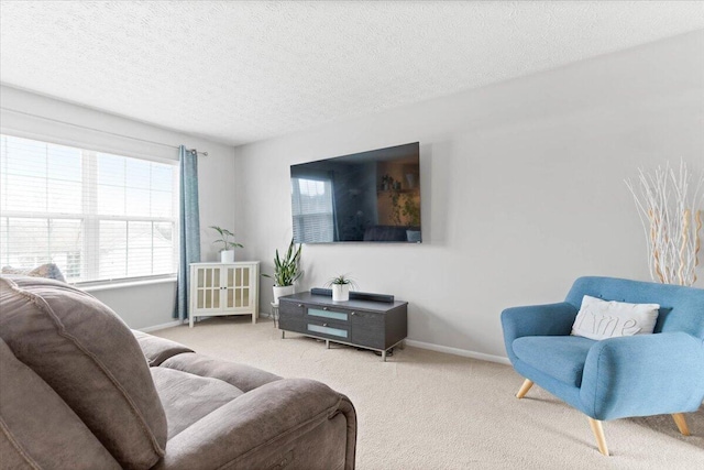 living room with baseboards, carpet, and a textured ceiling