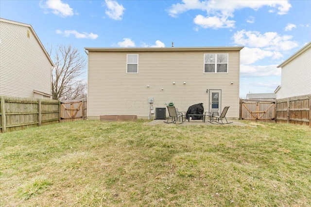 rear view of property featuring a fire pit, cooling unit, a fenced backyard, a yard, and a gate