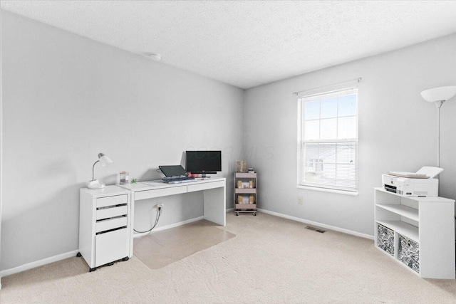 carpeted office space featuring baseboards, visible vents, and a textured ceiling