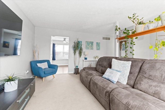 carpeted living room featuring visible vents, a textured ceiling, and ceiling fan