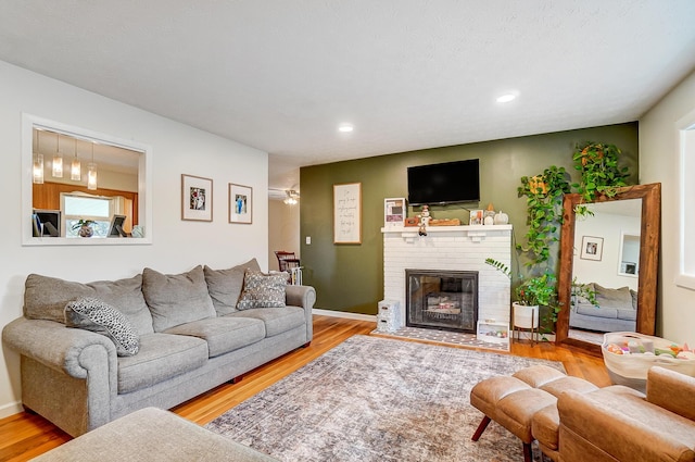 living room with a fireplace and light wood-type flooring