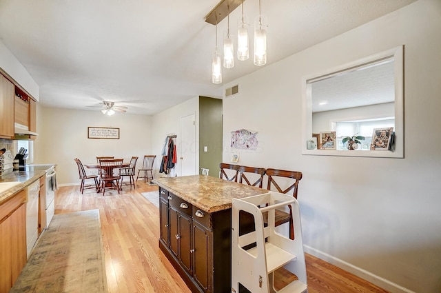 kitchen with ceiling fan, pendant lighting, white appliances, and light hardwood / wood-style flooring