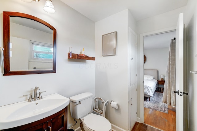 bathroom featuring hardwood / wood-style flooring, vanity, and toilet