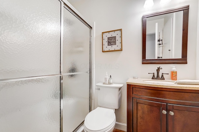 bathroom with vanity, toilet, and a shower with shower door