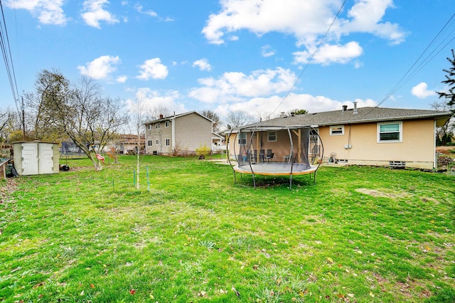 view of yard featuring a trampoline and a storage shed