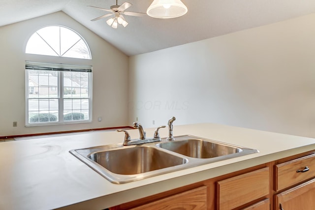 kitchen featuring vaulted ceiling, ceiling fan, and sink