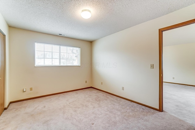 carpeted spare room with a textured ceiling