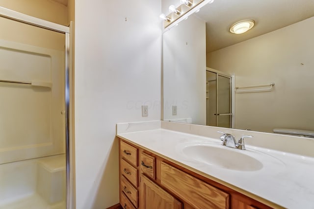 bathroom with vanity, an enclosed shower, and toilet