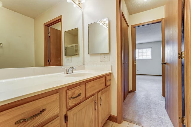 bathroom featuring tile patterned floors, vanity, and a textured ceiling