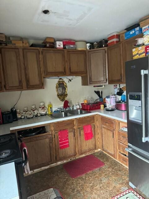 kitchen with electric stove, sink, and high end refrigerator