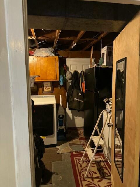 basement with black refrigerator and washer / dryer