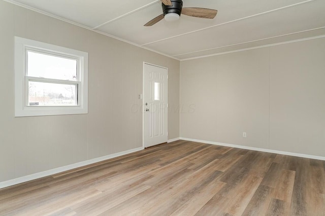 empty room featuring hardwood / wood-style flooring, ornamental molding, and ceiling fan