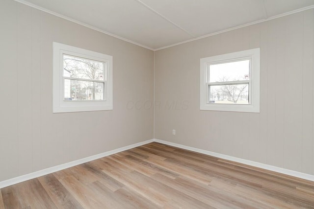 empty room with light hardwood / wood-style flooring and ornamental molding