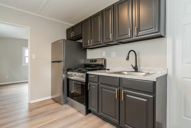 kitchen featuring crown molding, appliances with stainless steel finishes, sink, and light hardwood / wood-style flooring