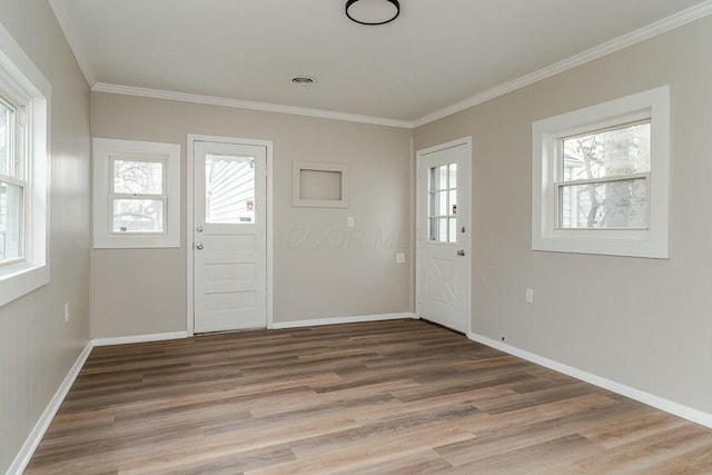 foyer with hardwood / wood-style flooring, a healthy amount of sunlight, and crown molding