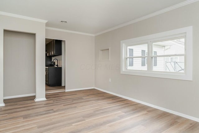 unfurnished bedroom with sink, crown molding, and light wood-type flooring