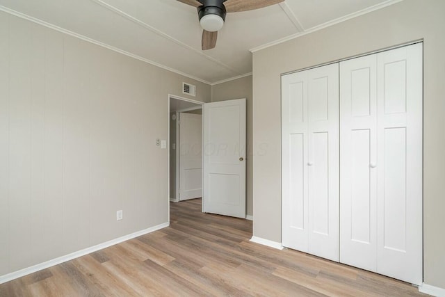 unfurnished bedroom featuring crown molding, light hardwood / wood-style floors, a closet, and ceiling fan