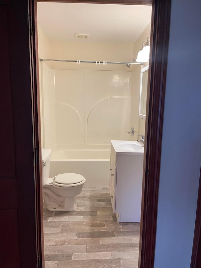 full bathroom with vanity, toilet, shower / bathing tub combination, and wood-type flooring