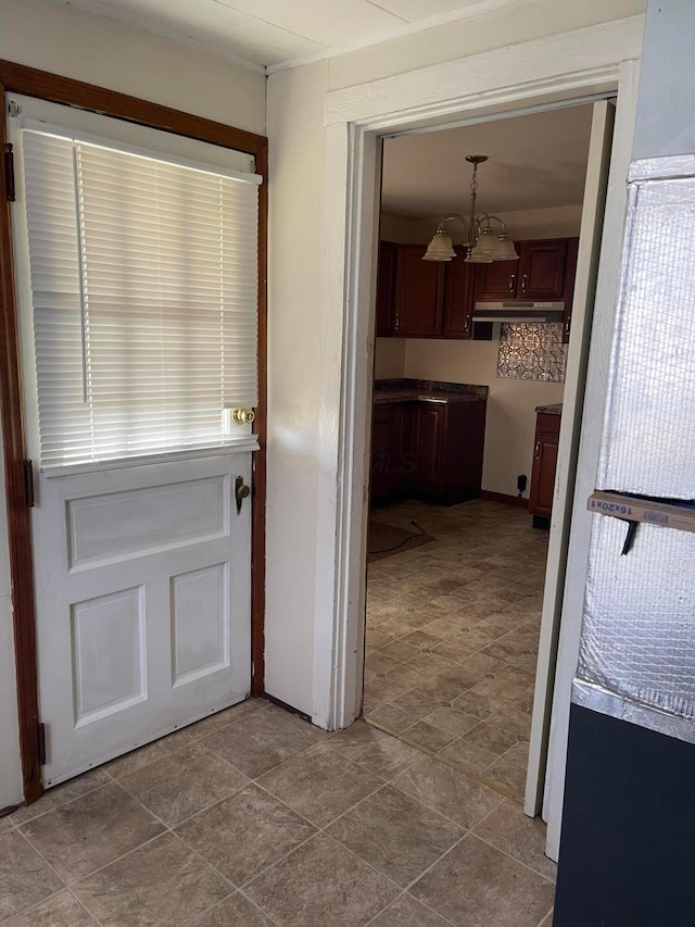 doorway to outside featuring a chandelier