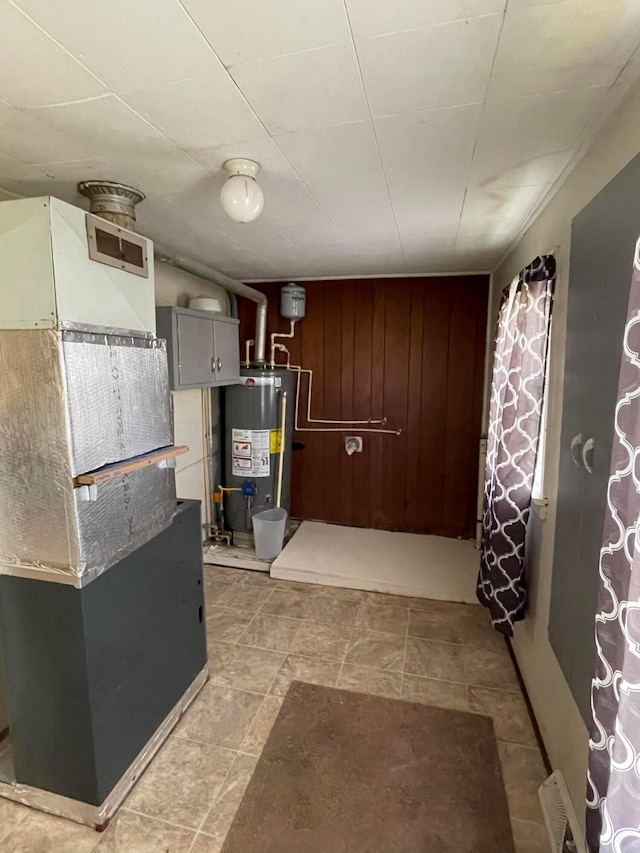 utility room featuring heating unit and gas water heater