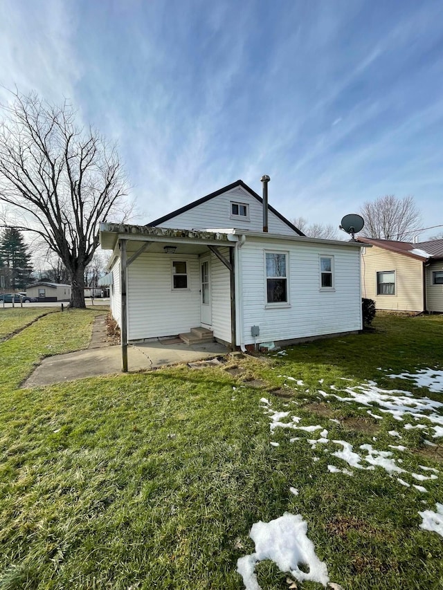 back of property featuring a patio area and a lawn