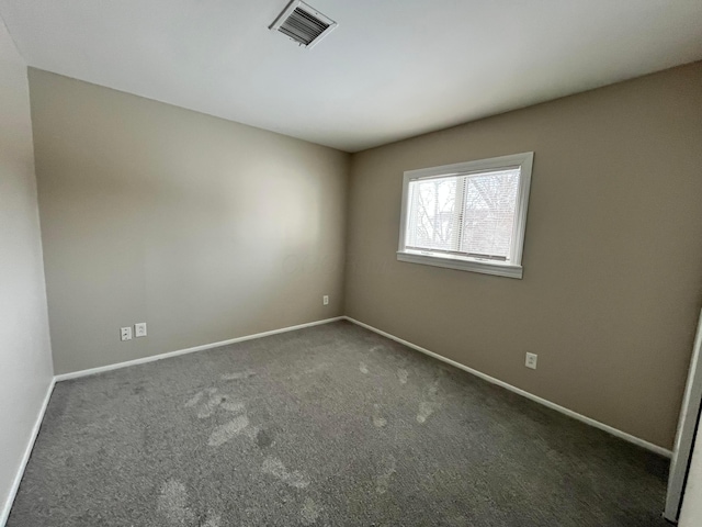 unfurnished room featuring dark carpet