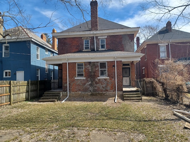 rear view of property with a lawn