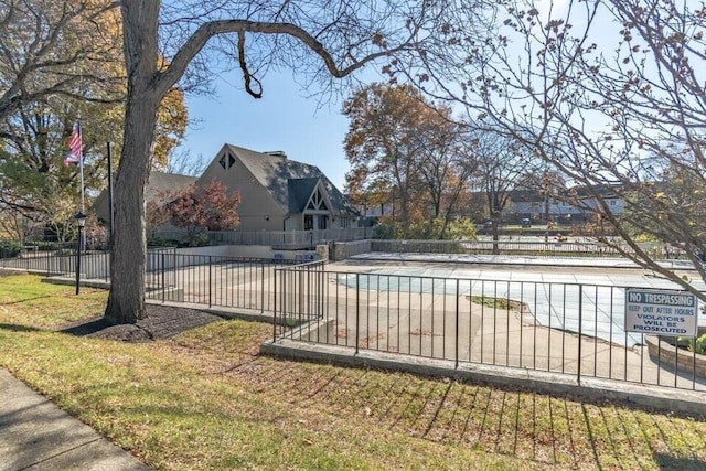 view of pool featuring a lawn