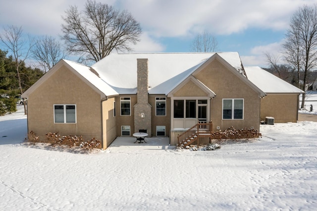 snow covered rear of property with cooling unit