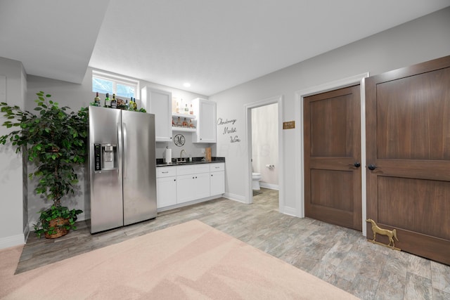 kitchen featuring stainless steel refrigerator with ice dispenser, sink, white cabinets, and light hardwood / wood-style flooring