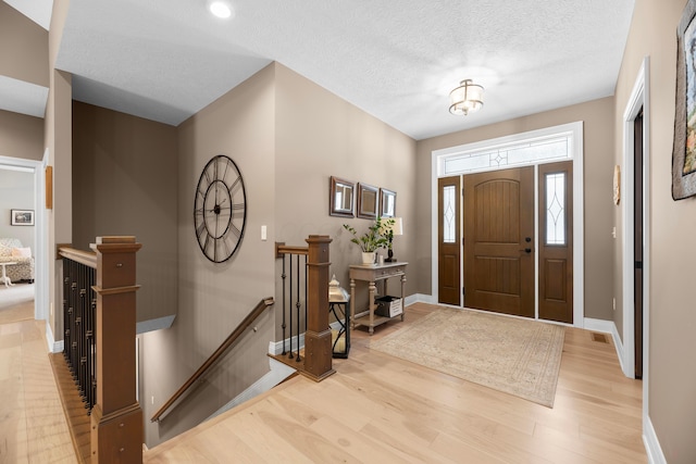 foyer featuring a textured ceiling and light hardwood / wood-style flooring