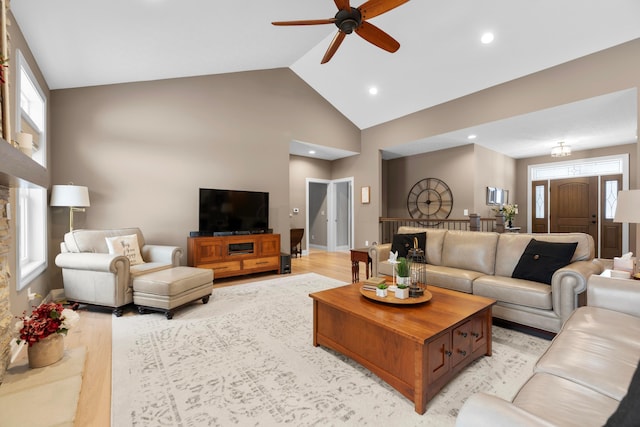 living room featuring high vaulted ceiling, plenty of natural light, light hardwood / wood-style floors, and ceiling fan