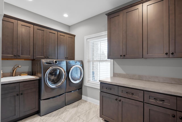 laundry area featuring cabinets, washing machine and dryer, and sink