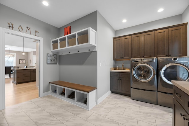 laundry room with independent washer and dryer, cabinets, an inviting chandelier, and sink