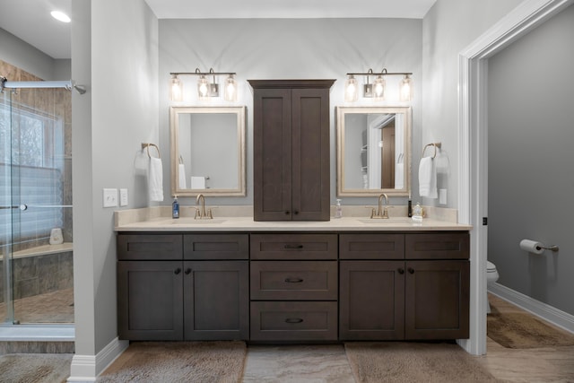 bathroom featuring an enclosed shower, vanity, and toilet