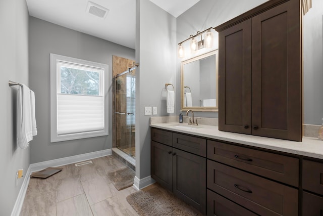 bathroom with vanity and a shower with door