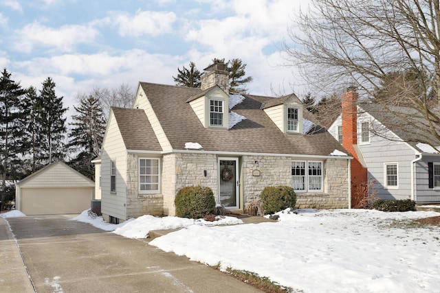 new england style home with an outbuilding, central AC unit, and a garage