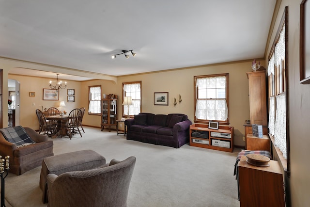 living room featuring crown molding, light colored carpet, and a notable chandelier