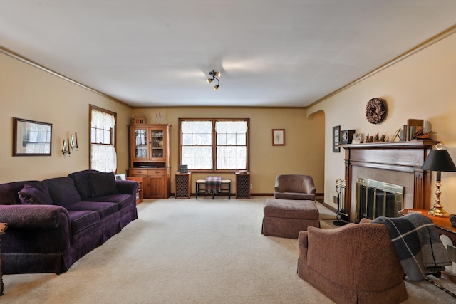 carpeted living room with ornamental molding and a tile fireplace