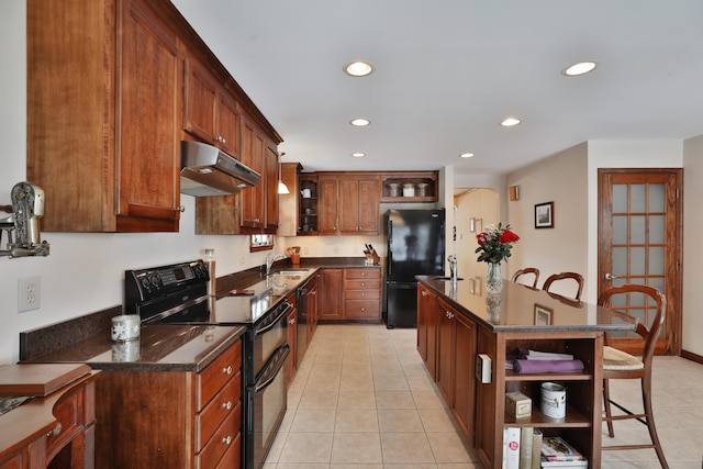 kitchen with light tile patterned flooring, a kitchen island, sink, and black appliances