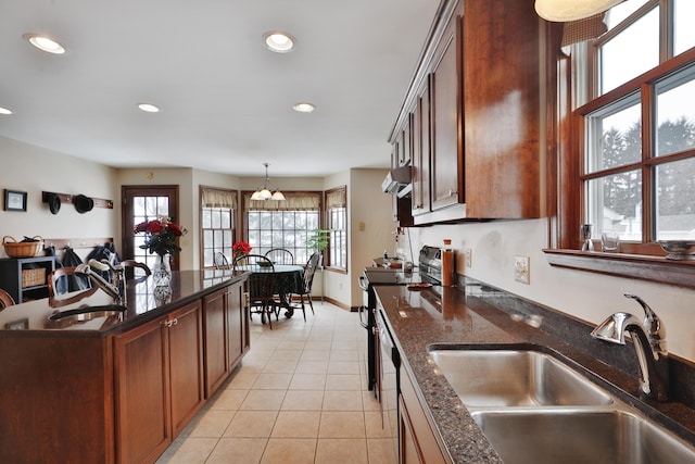 kitchen with light tile patterned flooring, sink, pendant lighting, and electric range oven