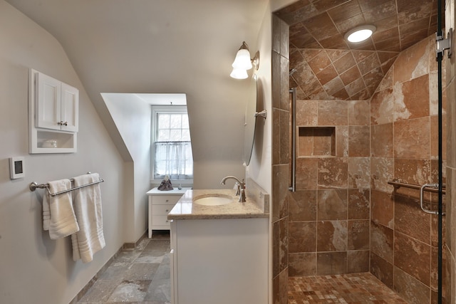 bathroom featuring vaulted ceiling, vanity, and a shower with door