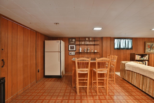 dining area featuring wooden walls and indoor bar