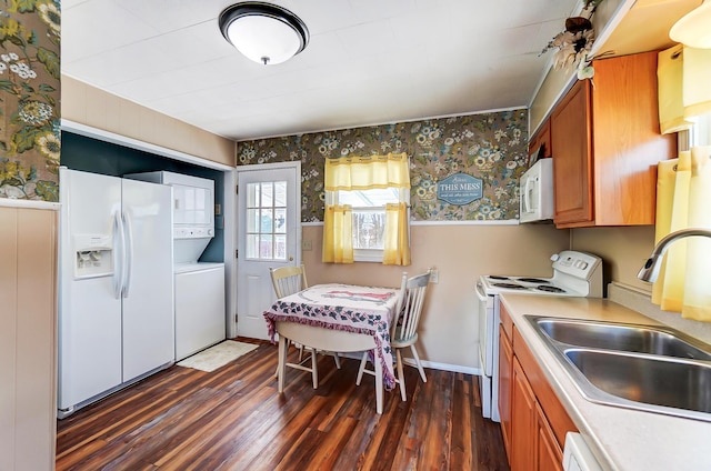 kitchen featuring dark hardwood / wood-style flooring, sink, white appliances, and stacked washing maching and dryer